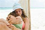 A mother and daughter sleeping on a hammock