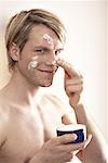 Man Applying Cream to Face