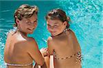 Mother and Daughter Sitting by Swimming Pool