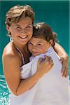 Mother and Daughter Standing by Swimming Pool, Wrapped in Towel