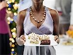 Close-up of Woman Holding Tray of Desserts at Christmas Party