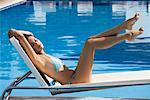 Woman Lounging in Chair by Swimming Pool