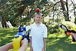 Kids Shooting Water Pistols at Apple on Boy's Head, Elmvale, Ontario, Canada