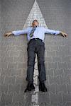 Businessman Lying on Cobblestone