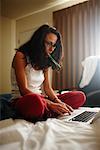 Woman Using Laptop Computer in Hotel Room