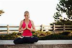 Woman Practicing Yoga on Ledge, Santa Monica, California, USA