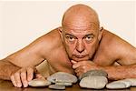 Homme torse nu avec des roches