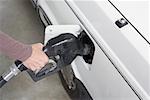 Woman refueling a car at a gas station