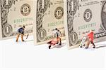 Figurines of manual workers with US dollar bills