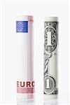 Rolls of European union euro note with US paper currency