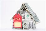 Sale tag attached with a miniature house made up of US dollar bills