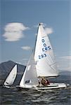 Three people participating in a sailboat race