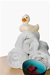 Rubber duck on the stack of rolled up towels