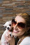 Close-up of a businesswoman holding a puppy and smiling