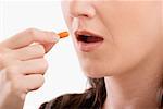 Close-up of a patient taking a capsule