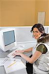 Portrait of a young woman working on a computer and smiling