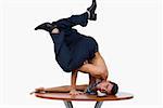 Portrait of a businessman doing a handstand on a table