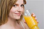 Portrait of a teenage girl drinking a glass of orange juice