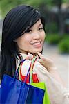 Porträt einer jungen Frau mit Einkaufstüten und Lächeln
