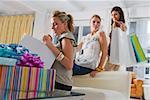 Jeune femme en vérifiant ses sacs shopping avec ses amies en arrière-plan