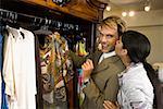Jeune femme embrasse un homme adult moyen dans un magasin de vêtements