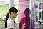 Side profile of a young woman window shopping