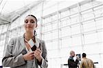 Businesswoman putting a passport with an airplane ticket in her coat's pocket