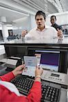 Businessman looking angry at a ticket counter in an airport