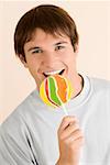 Portrait of a young man eating a lollipop