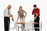 Two businessmen folding their shirt sleeves with a businesswoman standing beside them