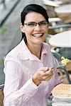 Portrait d'une femme d'affaires en train de déjeuner dans un café de trottoir