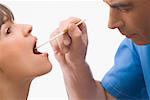 Nahaufnahme von einem männlichen Arzt untersucht eine reife Frau in den Mund
