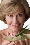 Portrait of a mature woman holding a bowl of herb