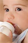 Close-up of a baby boy drinking milk from a baby bottle