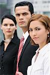 Portrait of a businessman and two businesswomen in a row