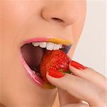 Close-up of a young woman eating a strawberry