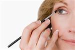 Gros plan d'une femme mature, appliquer l'eyeliner