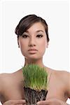 Portrait of a young woman holding wheatgrass