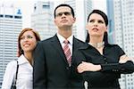 Close-up of a businessman standing with two businesswomen