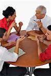 High angle view of three businessmen and a businesswoman discussing in a meeting