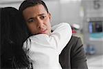 Close-up of a businessman and a businesswoman embracing each other at an airport