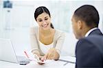 Professional woman reviewing brochure with customer