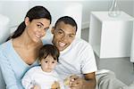 Parents and toddler daughter smiling at camera, portrait