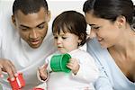 Parents and toddler girl playing with toys together