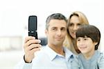 Family looking at cell phone together, focus on phone