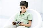 Boy playing handheld video game