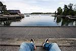 Personne assise sur le quai flottant dans la péninsule scandinave Fjaderholmarna, archipel de Stockholm, Stockholm, Suède