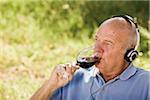 Man Listening to Music and Drinking Red Wine