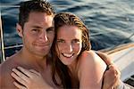 Young couple on sailboat, smiling