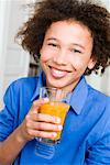 Garçon souriant avec un verre de jus d'orange